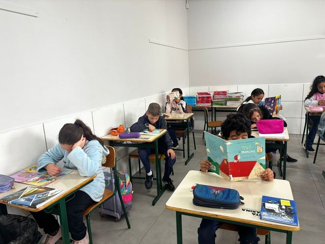 Estudantes lendo livros em sala de aula