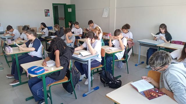 Estudantes lendo livros em sala de aula